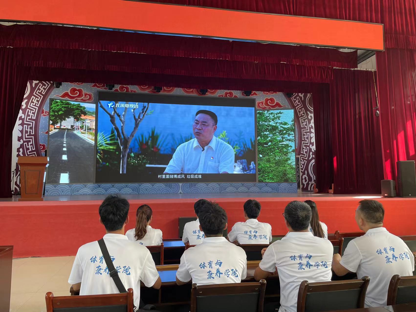 图为实践队员在半山村观看宣传视频，学习党建经验