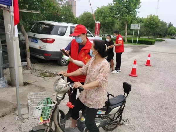 志愿者在檢查過(guò)路人的健康碼 郭利芬 攝